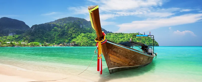 Thailand — longtail boat in a limestone bay